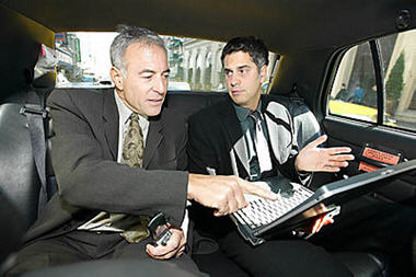 business men with laptop in car